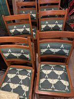 Six oak mission style dining chairs, showing the cushion pattern and arrangement in the set