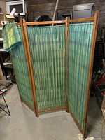 Full view of the three-panel privacy screen standing with slight angles visible, showing the hinged construction and fabric inserts.