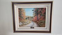 Framed oil painting showing a scenic autumn wooded road, signed by artist Cole Bowman, overall frame size 31x24 inches.