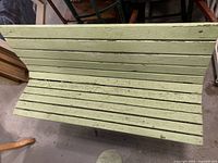 Top-down view of green slat seat showing paint wear