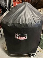 Black King Kong BBQ cover with logo shown fitted over grill