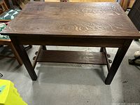 Rectangular top and four straight legs with lower shelf visible from front.