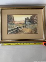Full view of the framed watercolor painting showing the entire farm scene and frame with measuring tape indicating frame size.