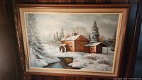 Full view of the framed oil painting showing the old mill in a snowy setting beside a stream.
