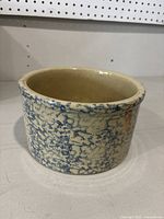 Front side view of the pottery spongeware crock showing blue sponge pattern on cream ceramic body.