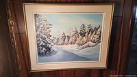 Framed winter landscape oil painting featuring snow-covered trees and a snowy path under a light blue sky.