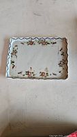 Top view of rectangular ceramic dish with floral patterns and scalloped edges