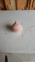 Closed shell box on a table showing pink and white striped shell design with knob lid.