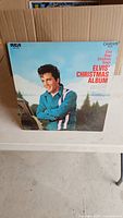 Front view of Elvis' Christmas Album vinyl LP showing Elvis Presley on the cover in a wintery backdrop.