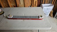Top-down view of the wooden model ship on a table, showing the full length and the cargo deck painted in gray with the red and white hull marked with 'Canada Steamship Lines'.