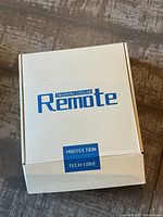 Closed white box labeled 'Remote Training Collar' with blue text and protective tech-love and protection labels.