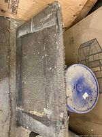 Top view of the furniture dolly showing worn brown carpet surface with visible stains and frayed edges.