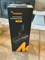 Box packaging showing Maono PD100 XLR Dynamic Microphone branding and product image.