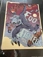 Full view of the Foo Fighters concert poster showing the stylized figure and band name graphics.