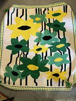 Full view of the tapestry showing the yellow and green floral design with black stripes on a cream background.