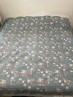 King size bedspread fully spread on a bed with detailed floral pattern visible.