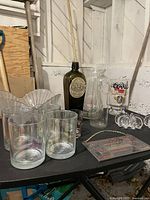 Shows lot including two pearlescent glasses, antique green bottle, propagation vase, glass fruit bowl, Coors goblet, chain with small glass dish, flower-shaped candle holders