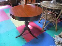 Photo of vintage 1960s Mersman drum table, round top with mahogany finish on colorful foam floor mat.