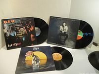 Three vinyl albums with record and cover displayed; Styx, Julian Lennon Valotte and REO Speedwagon Hi Infidelity visible