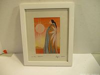 Full view of framed artwork depicting a woman with a sun in the background in warm tones, signed by Maxine Noel.