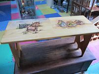 Photo of wooden bench showing full length and the painted top with chair designs.