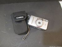 Canon Sure Shot 80u camera with black Canon carrying case on a black surface