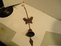 Full view of the cast iron wind chime showing butterfly and bell with chain