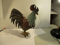 Side view showing the full profile and metal feather detail on the rooster sculpture.