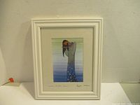 Framed artwork titled 'Mother Earth's Tears' by Maxine Noel hanging on wall.