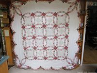 Full view of the quilt hanging, showing overall pattern and scalloped edges.