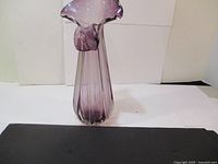 Front view of the tall purple vase showing vertical ribbing and ruffled top edge.