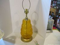 Full view of vintage amber crackle glass table lamp with brass base and hardware, lamp unplugged and no bulb installed.