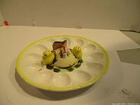 Top-down view of the vintage ceramic egg plate with central chicken and two chick salt and pepper shakers showing details and color.