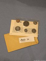 Photo showing six 1968 Canadian coins sealed in original plastic packaging attached to a card with text and an envelope below.