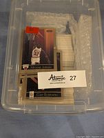 Plastic storage container with visible Michael Jordan and Cliff Robinson 1990 Skybox basketball cards inside.