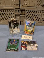 Four Upper Deck hockey cards displayed upright on small stands and flat on surface, showing autographs and limited edition details