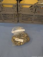Bag of brass buttons with handwritten label indicating 139 Canadian Army brass buttons made in Montreal.