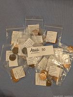 Photo of multiple individually bagged Canadian coins from various years with handwritten tags describing year and errors.