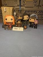 Six Harry Potter Funko Pop figures displayed with a placard, showing Hermione Granger, Harry Potter, Bellatrix Lestrange, Newt Scamander, Niffler, and a pink-haired female character.
