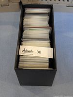 Black card storage box labeled Atomic Collectibles #36 filled with Pokemon cards