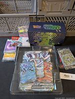 Overview of sealed deck box, sealed promo card sleeves, EX cards in plastic tray and loose bulk cards