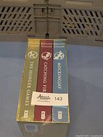Top view of the sealed box set showing the spines of the three books with gold foil accents and individual symbols for each book.
