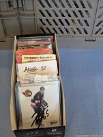 Box of assorted vintage hockey trading cards showing multiple card packs including a signed card from the Ottawa Senators.