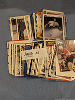Top view of a large pile of assorted vintage NHL hockey trading cards arranged in stacks with some card faces visible and featuring famous players.