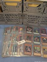 Multiple Yu-Gi-Oh cards arranged in plastic sleeves, showing a variety of monster cards.