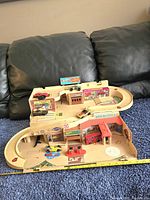 Overview of entire Hot Wheels Service Centre playset with multiple vintage die-cast cars arranged on ramps and service bays. Shows complete structure and painted decals.