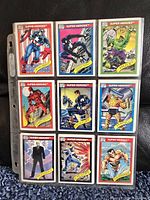 Photo showing 9 Marvel Super Heroes trading cards featuring characters like Captain America, Daredevil, Professor X, Hulk, Spider-Man, Thing, Cyclops, and Wolverine in protective sleeves.