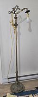 Full length view of the antique cast metal floor lamp showing overall height and structure.