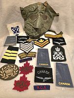 Lot showing various Canadian military patches and an olive green gas mask