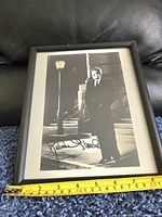 Full view of framed black and white photograph of Robert Stack on steps near lamppost with signature visible at bottom left.